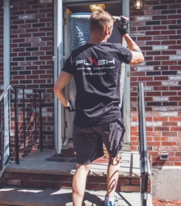 Image: a Flash Moving crew member moving large furniture into a building.