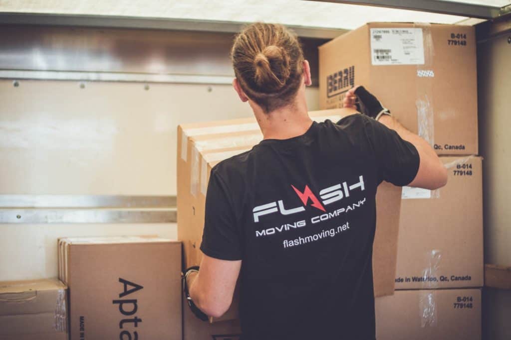 Flash Moving Company mover handling packed boxes efficiently for a last-minute move.